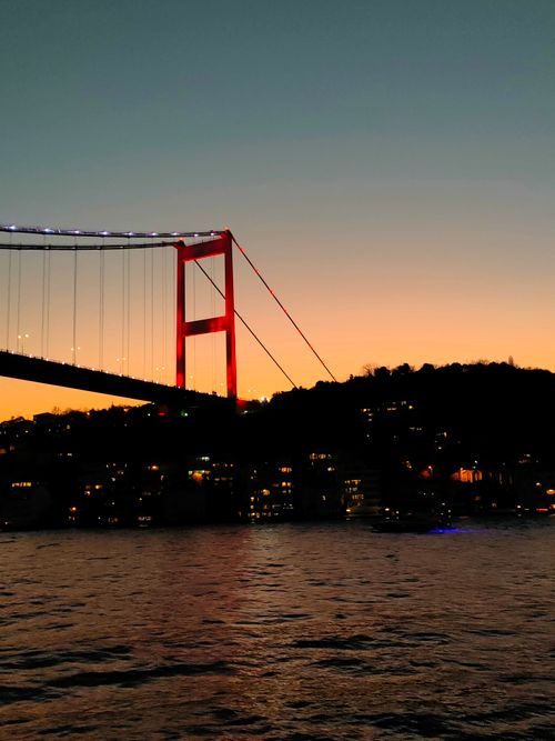 Free Stunning view of the Bosphorus Bridge in Istanbul at sunset over the calm sea. Stock Photo