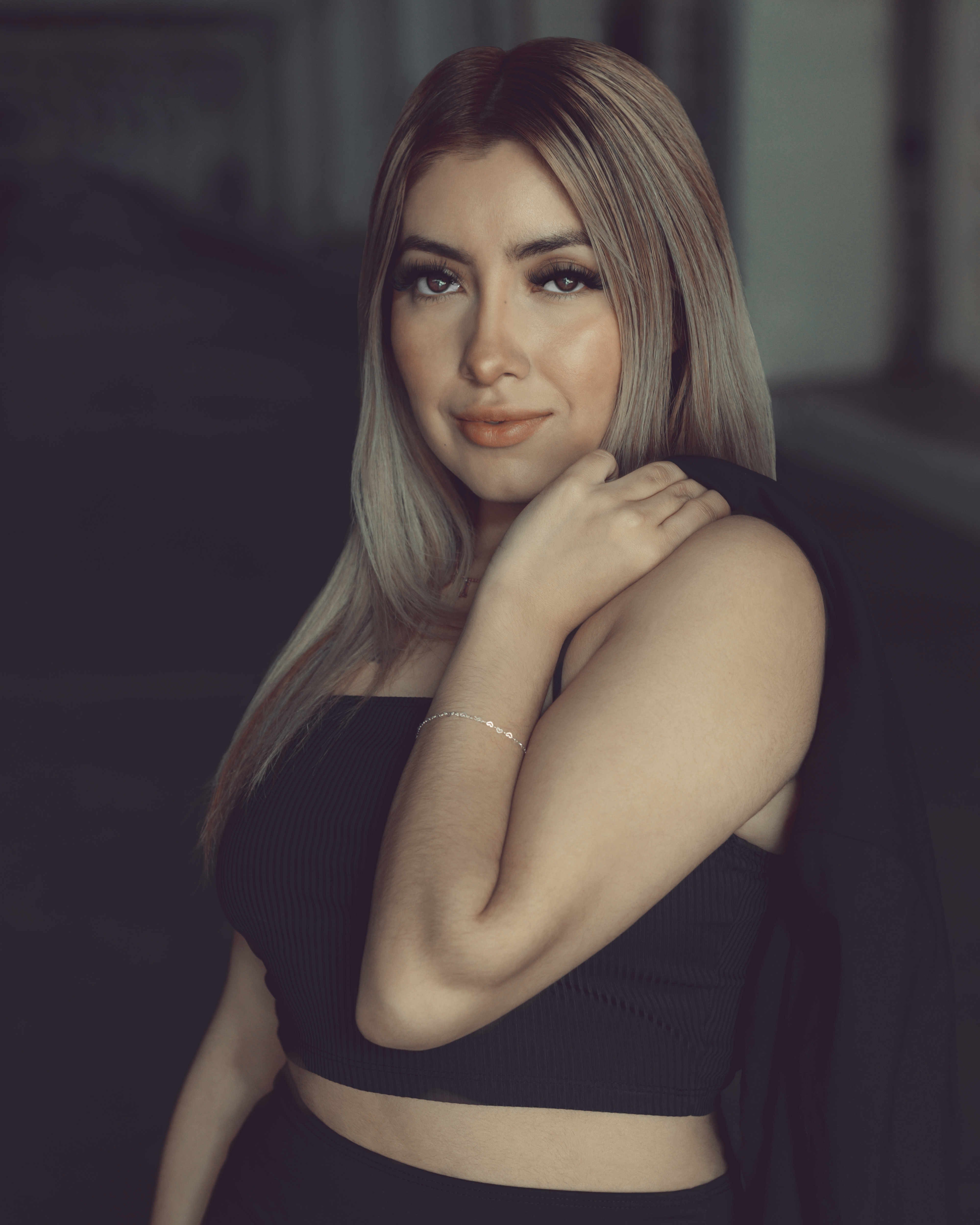 Elegant portrait of a fashionable woman with blonde hair posing confidently indoors.