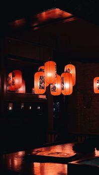 Warm-toned Japanese lanterns creating a cozy atmosphere in a dimly lit room, perfect for serene settings.