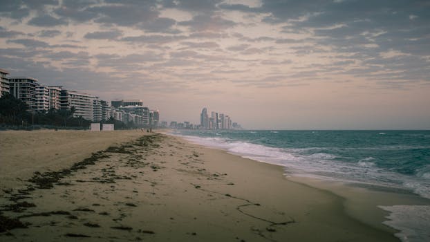 Tranquil view of Miami Beach shore with skyline in the distance during twilight.