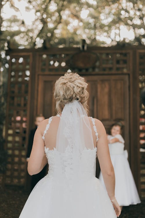 A bride walking down the aisle in front of a wooden door