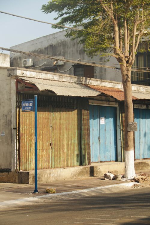 Free A quiet urban street showcasing rustic buildings and colorful aged doors. Stock Photo