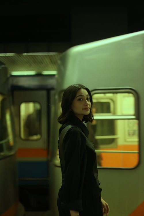A woman standing in front of a train