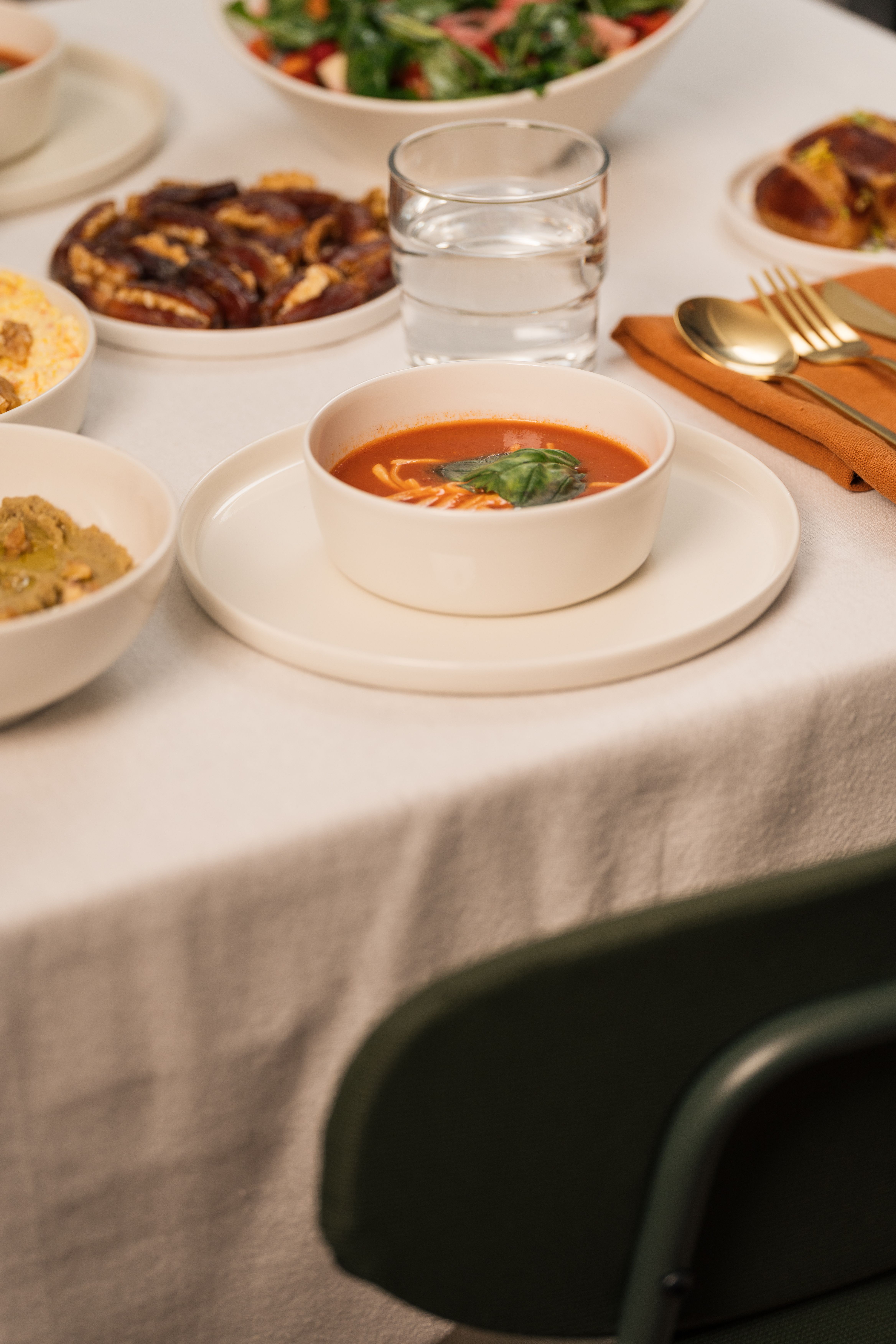 A beautifully set table featuring lentil soup, salads, and desserts, perfect for a cozy dinner.