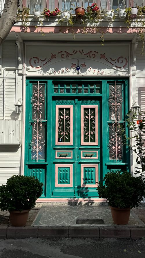 Free Charming vintage wooden door with green and pink details, adorned with floral accents. Stock Photo