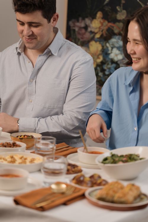 Free A couple enjoying a hearty meal together, showcasing vibrant food and laughter. Stock Photo