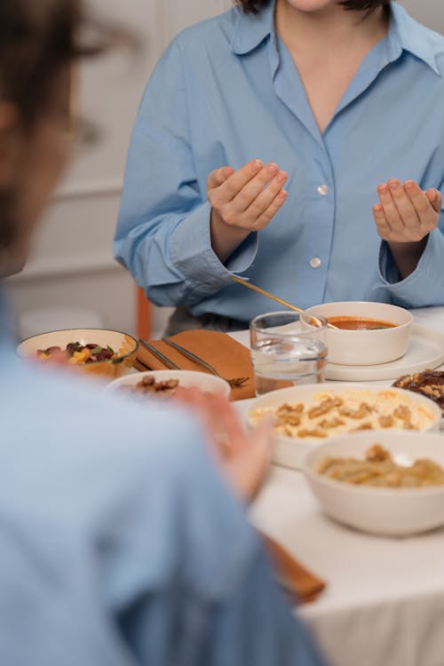 A woman sitting at a table with food and a plate