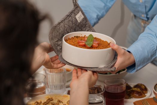 Two people sharing a dish of homemade dessert during a cozy dinner party.