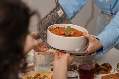 Free Two people sharing a dish of homemade dessert during a cozy dinner party. Stock Photo