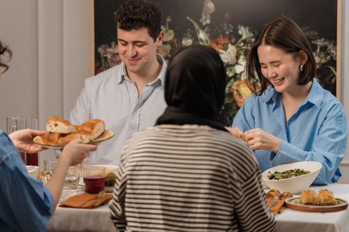 Free A cheerful group of friends enjoying a dinner party with delicious food and laughter. Stock Photo
