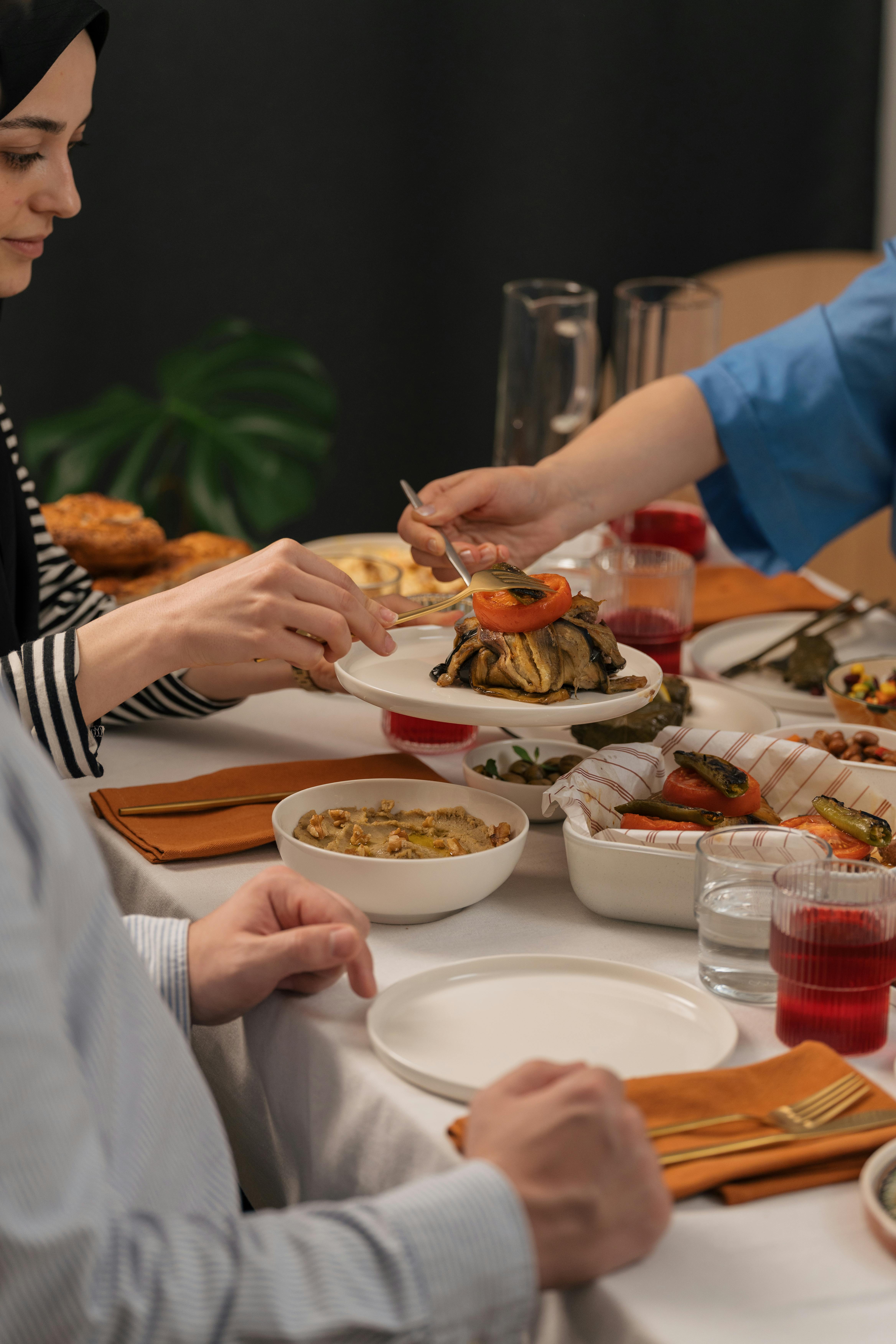 A table laden with diverse dishes from different campervan kitchens, showcasing a variety of cuisines.