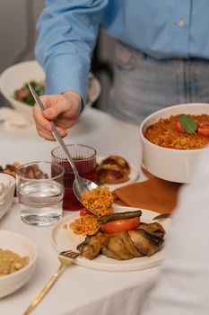 Warm indoor dinner setting with diverse dishes, glassware, and a casual atmosphere.