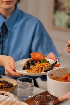 Close-up of vegetarian dinner being shared at a cozy indoor setting. Features vibrant food and engaged diners.