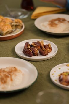 Delicious close-up of Middle Eastern sweets including dates with nuts and baklava, perfect for food blogs.