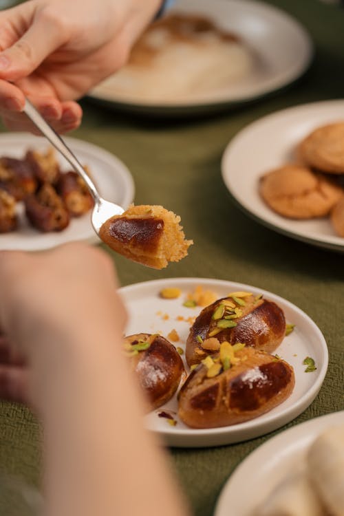 A person is holding a spoon over a plate of food