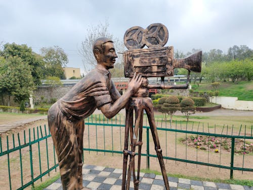 A statue of a man holding a camera