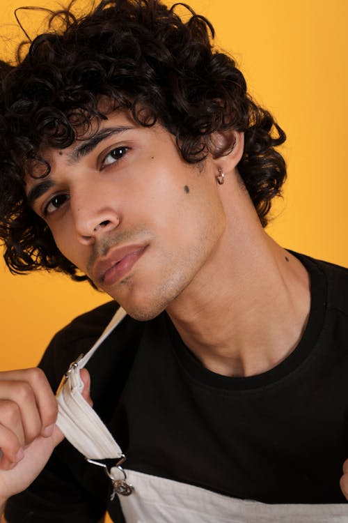 A young man with curly hair and a black shirt