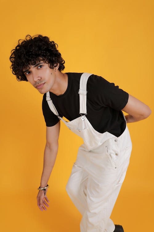 A man in overalls posing for a photo