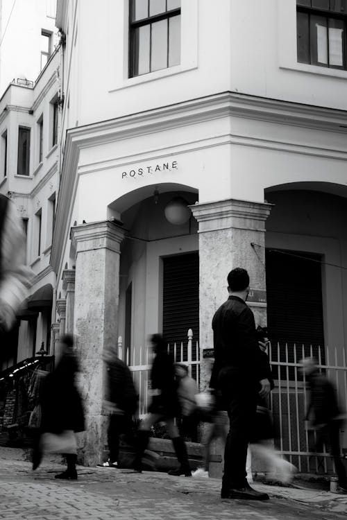 A black and white photo of people walking down a street