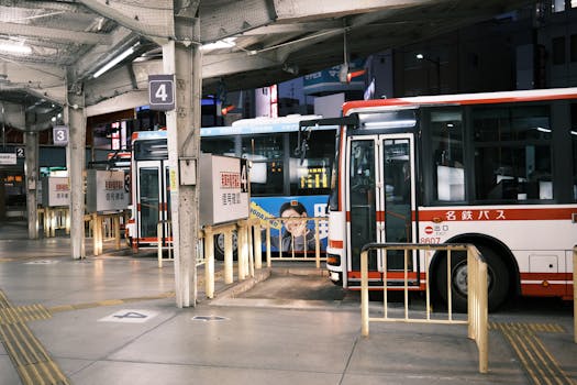 A bustling bus station in Okazaki, Aichi, Japan at night, showcasing lined buses.