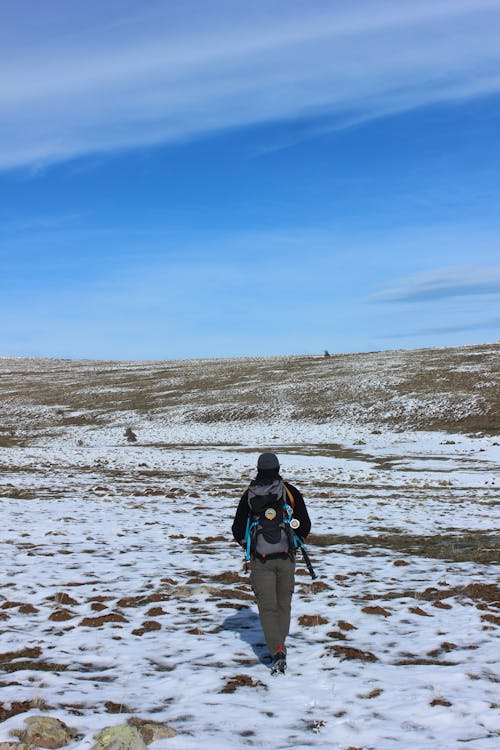 A person walking through a snowy field with a backpack