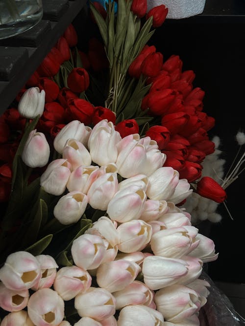 A bunch of tulips in a vase with red and white flowers