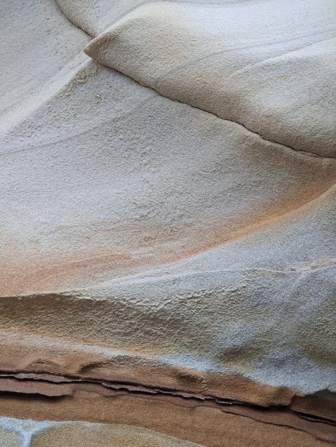 Close-up of a smooth, eroded rock texture displaying unique geological patterns.