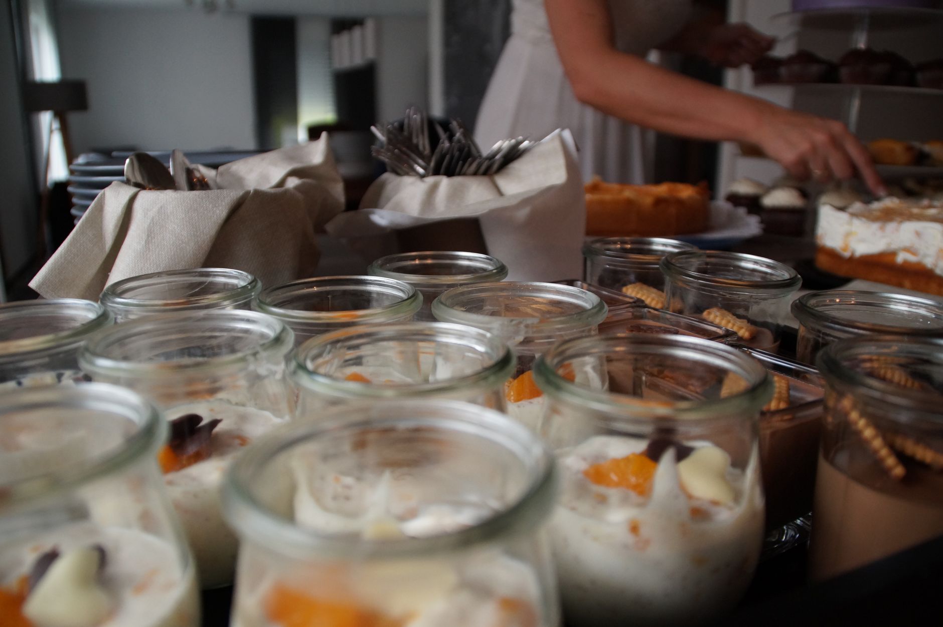 Appetizing desserts in glass jars arranged on an indoor buffet table, ready for serving.
