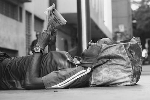 Monochrome Photo of Man Reading Newspaper