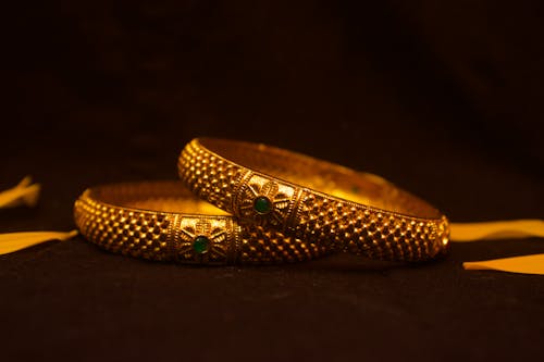 Golden bangles with green stones