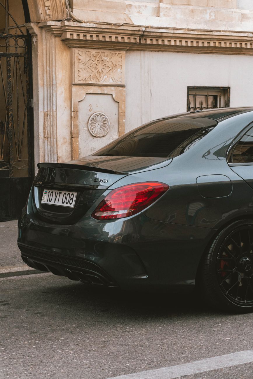 An elegant luxury sedan parked near a classical building entrance.