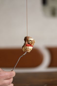 Close-up of a pancake bite with strawberries topped with chocolate, showcasing food photography art.