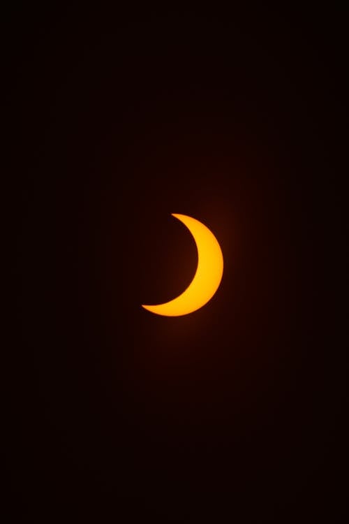 Free View of an Orange Crescent Moon against Dark Night Sky  Stock Photo