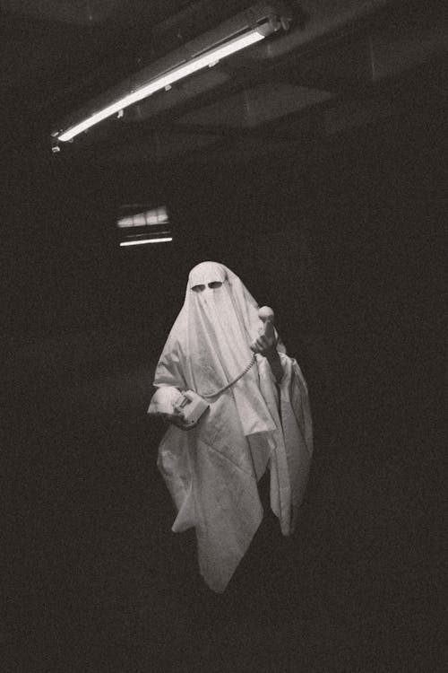A man in a ghost costume holding a knife