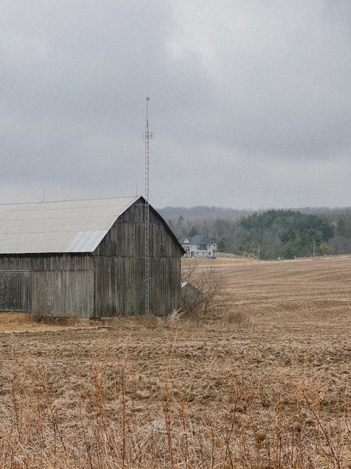 A barn in a field with a radio tower