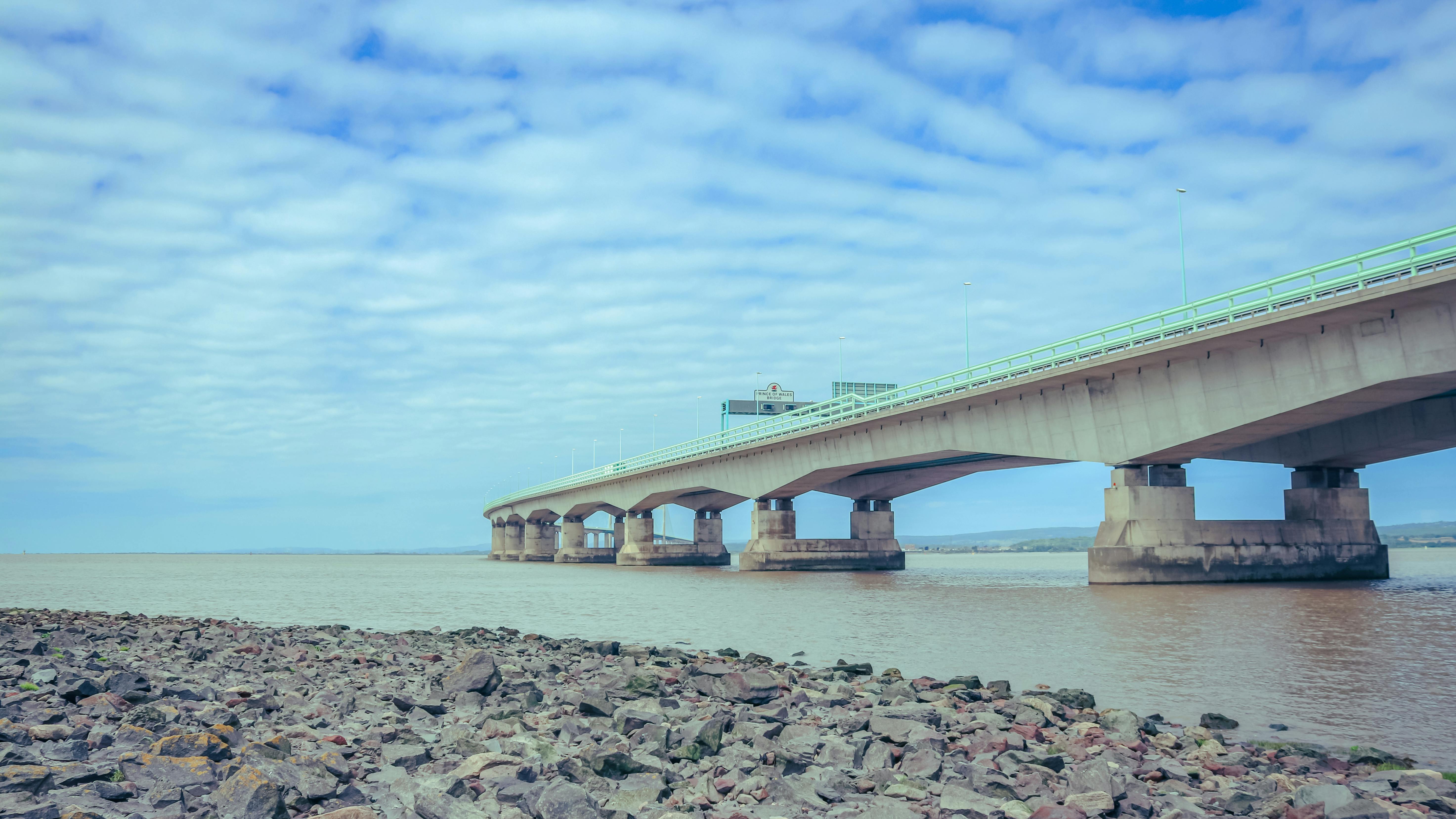 A captivating view of the Second Severn Crossing bridge spanning over the river, under a cloudy sky.