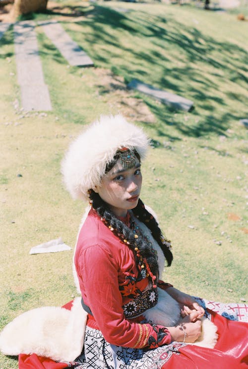 Young Woman in Mongolian Attire Sitting on the Grass