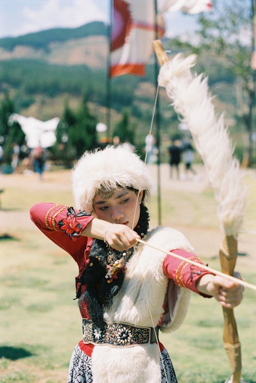 Young Woman in Folk Costume Aiming with a Bow