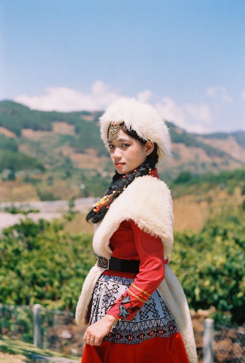 Young Woman in an Embroidered Red Dress Fur Hat and Scarf