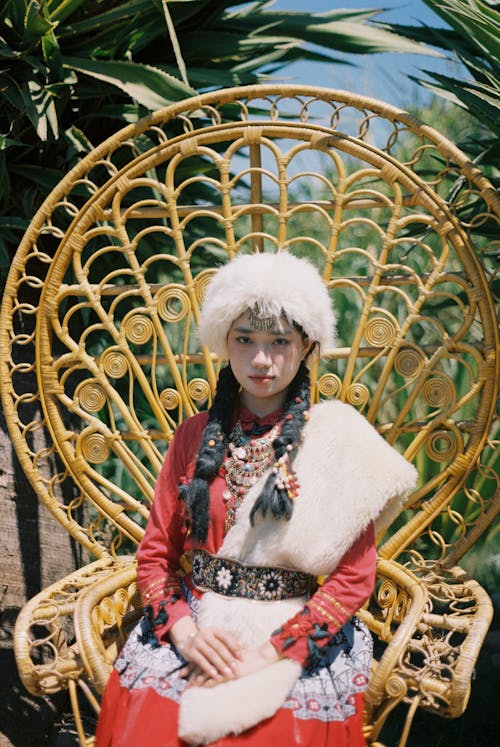  Young Woman in Folk Costume Sitting in the Peacock Wicker Throne