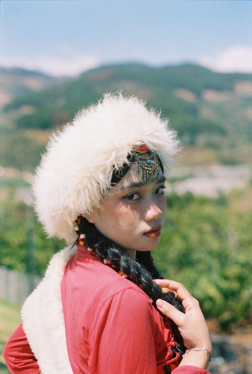 Young Woman in a White Fur Hat and a Red Dress