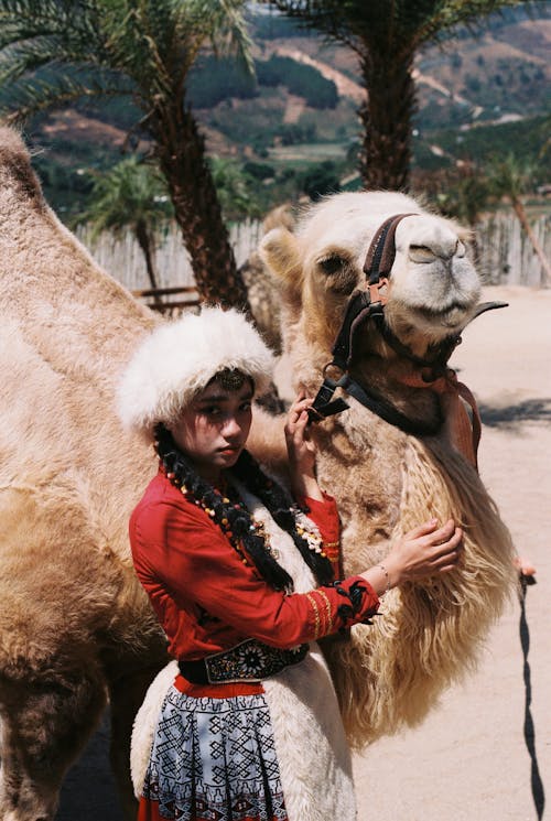 Asyalı kadın, deve, dikey atış içeren Ücretsiz stok fotoğraf