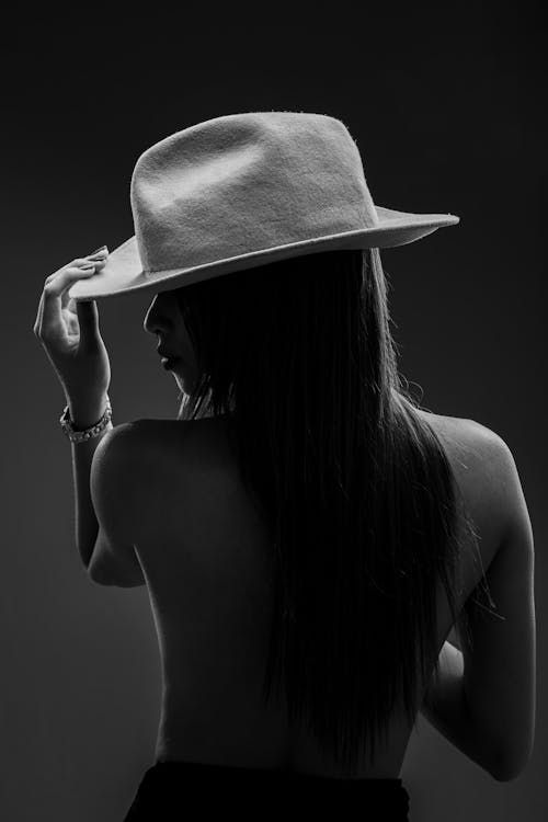A woman in a hat is posing for a photo