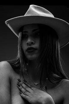 Elegant monochrome portrait of a woman wearing a hat, showcasing beauty and style.