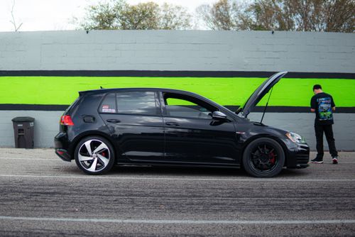 Free Side view of a black Volkswagen Golf GTI with hood open, parked on roadside. Stock Photo