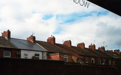 Free Rustic row houses with chimneys in Edinburgh, showcasing Victorian architecture under a bright sky. Stock Photo