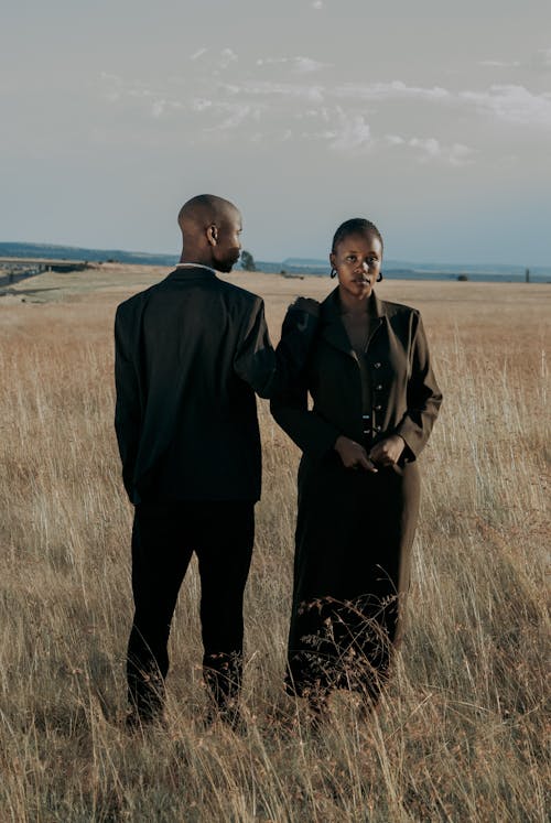 Man and Woman in Suits on Field