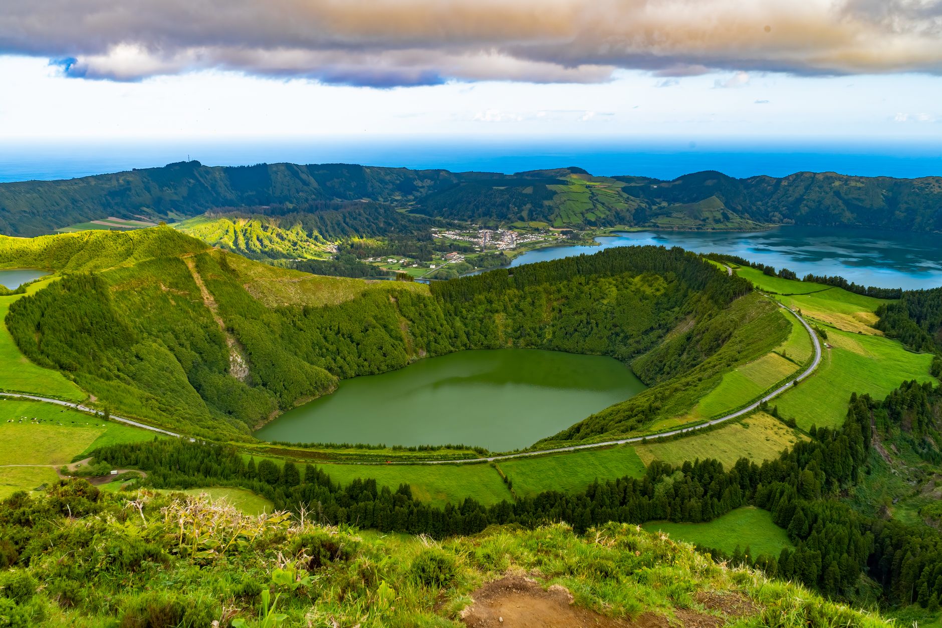 Explore the breathtaking view of lush green caldera landscapes in the Azores, Portugal with serene lakes and rolling hills.