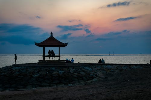 Silhouette of People Sitting on Bench by the Sea 