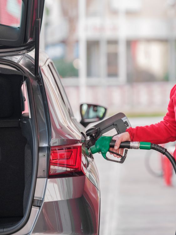 A person refueling a car at a gas station pump